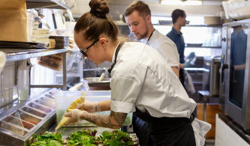 Kock som förbereder mat i restaurangkök