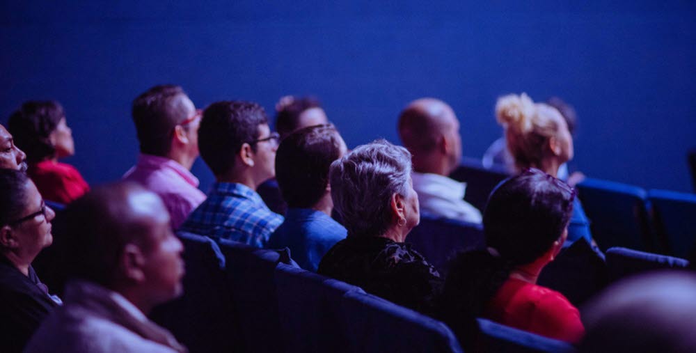 Personer i biosalong tittar på film