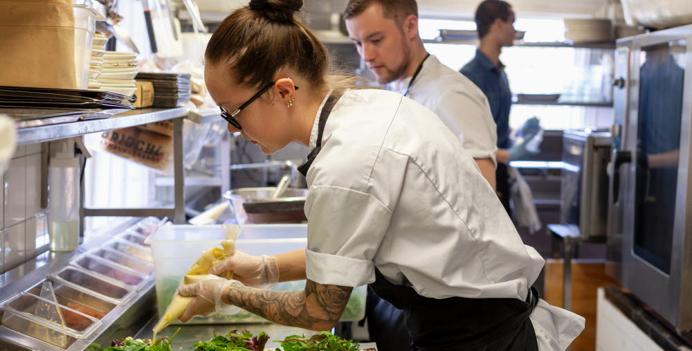 Kock som förbereder mat i restaurangkök